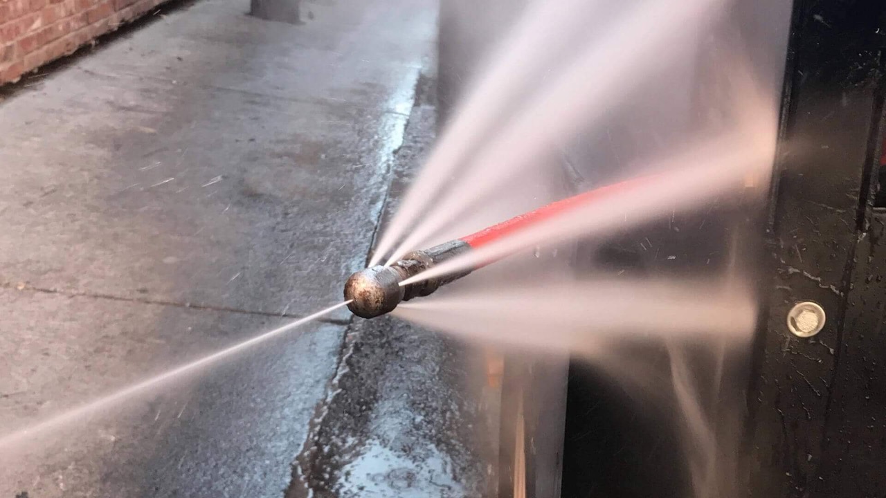 High pressure hydro jetting nozzle clearing a drain