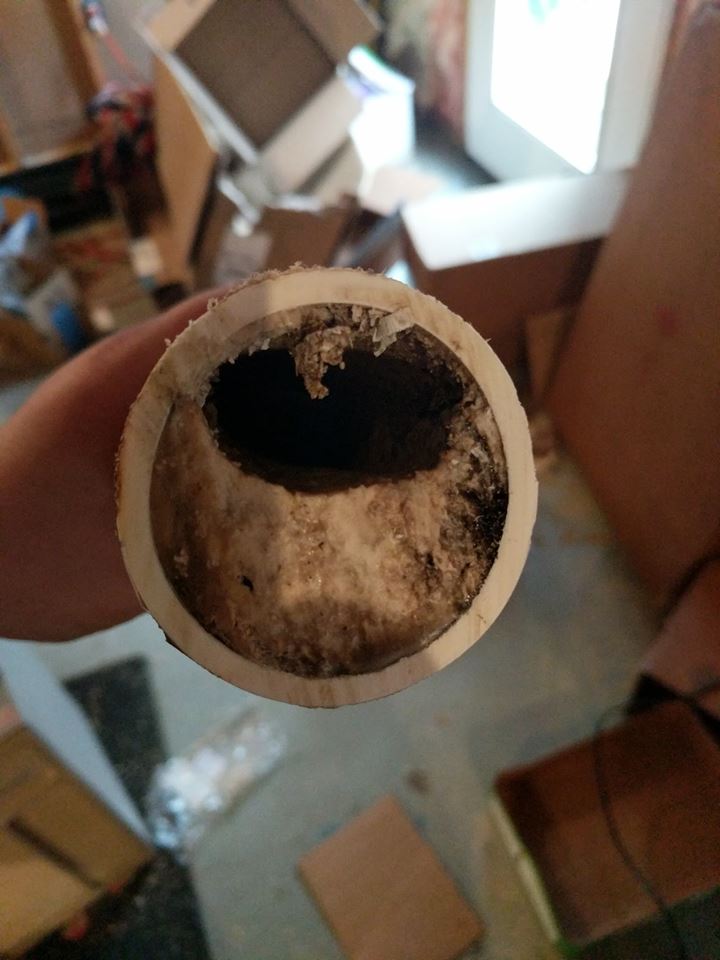Technician cleaning a sink and tub drain line